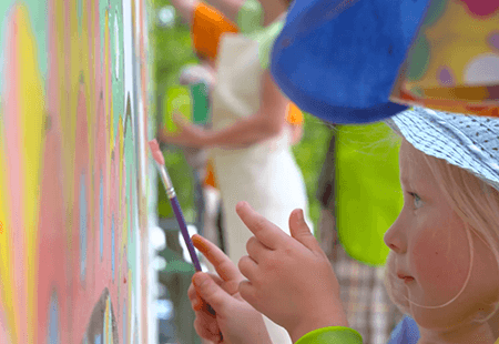 Kid painting on a canvas.