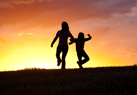 Two kids holding hands in the sunset